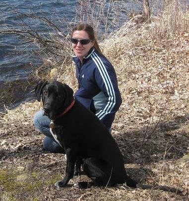 Black lab mix and woman sitting by the lake together at Maplewood State Park Minnesota